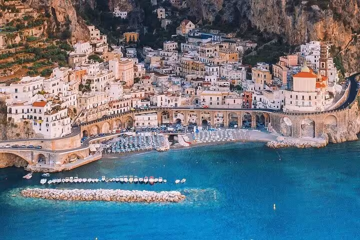 Aerial view of Positano's cliffside village with colorful buildings and a vibrant beach on the Amalfi Coast, Italy.