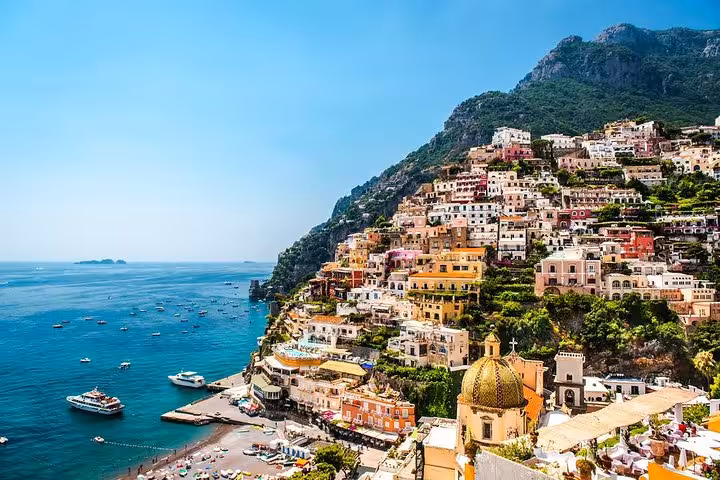 Scenic view of colorful cliffside buildings overlooking the turquoise sea in Positano on the Amalfi Coast.
