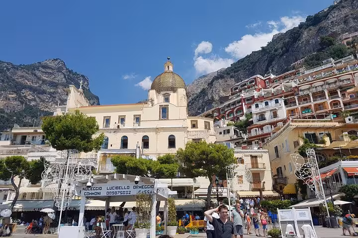 Positano main square with church dome and cliffside houses, highlight of Amalfi Coast day trip from Rome