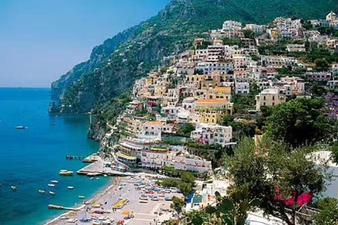 Colorful cliffside houses and beach boats in Positano on a shared Amalfi Coast private tour along the turquoise sea
