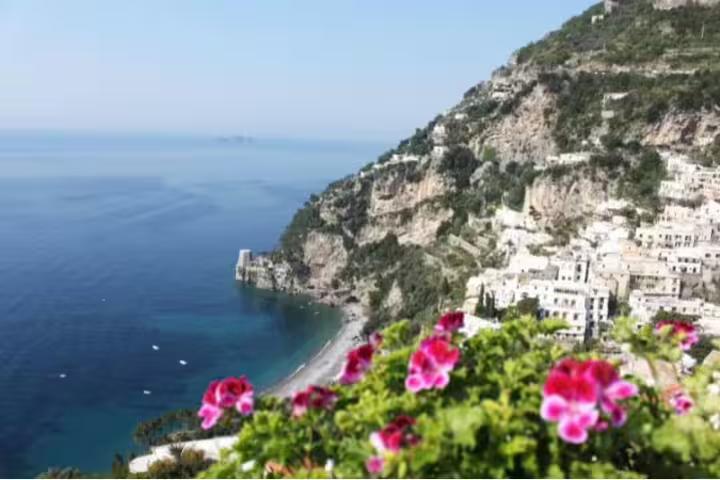 Panoramic view of Positano’s cliffside houses and Amalfi Coast beach with bright flowers on a private tour from Pompeii