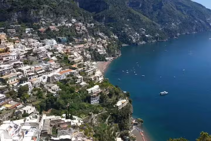 Clifftop houses and boats along the turquoise coastline of Positano on the Amalfi Coast from a Sorrento shore tour