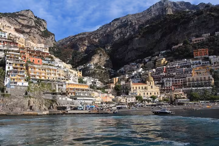 Stunning view of Positano's colorful cliffside houses on the Amalfi Coast, Italy, with blue sea and sky backdrop.