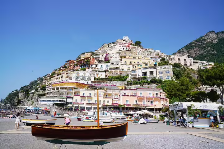Scenic view of Positano's vibrant hillside buildings with a boat in the foreground on the Amalfi Coast tour.