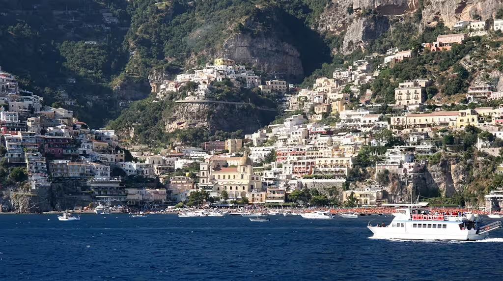 Colorful cliffside houses and boats off Positano on the Amalfi Coast, starting point for private Pompei and Vesuvio tours