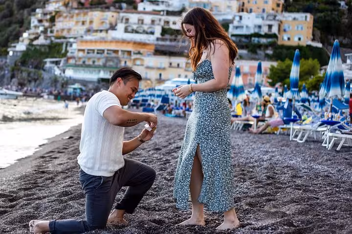 Romantic beach proposal in Positano on the Amalfi Coast with vibrant seaside backdrop and joyful couple.