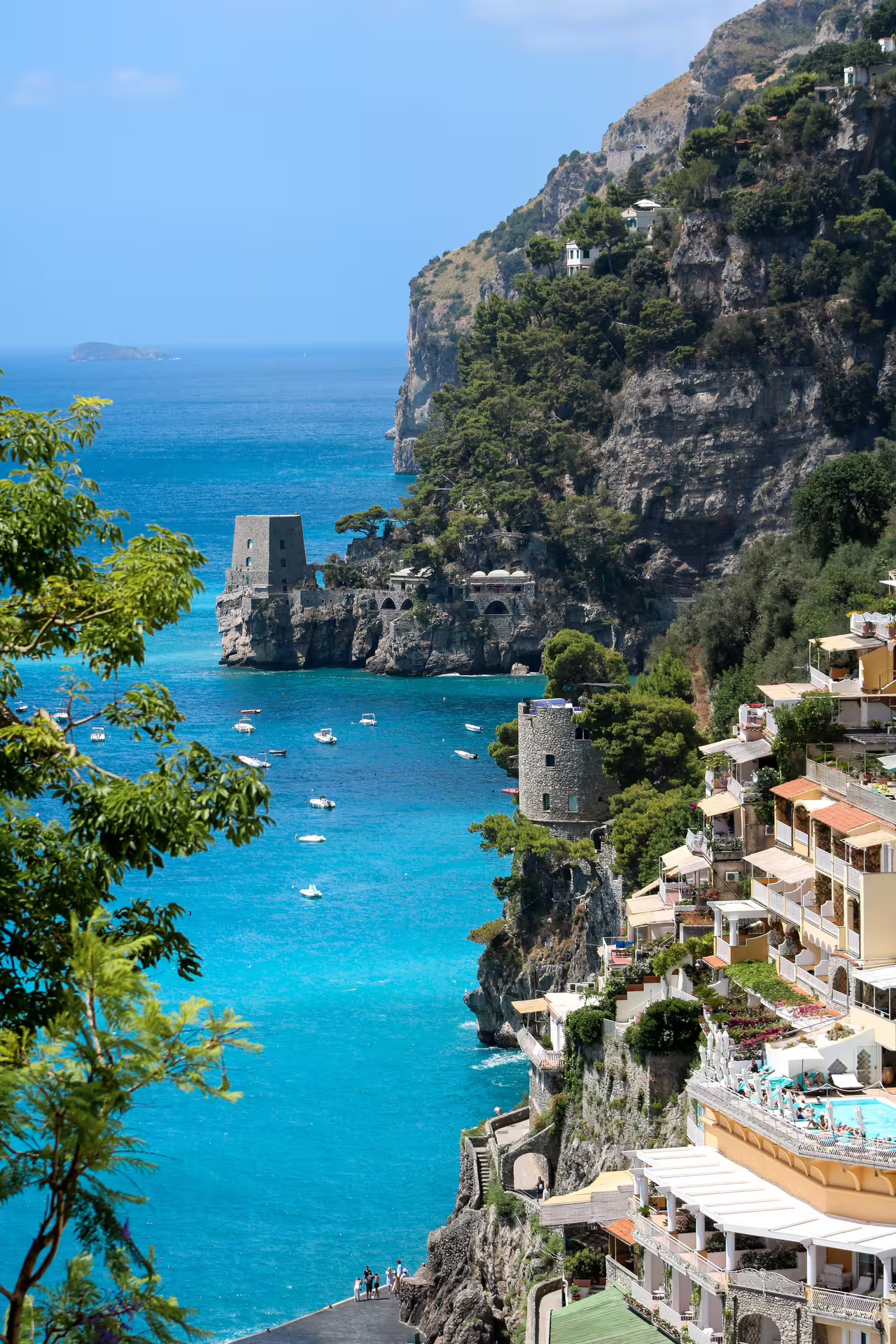 Positano cliffs and turquoise sea on Amalfi Coast day tour from Naples, with boats and coastal villas