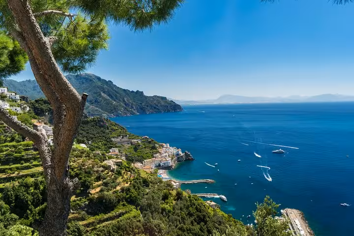 Breathtaking vista of Positano with turquoise sea, lush hillsides, and boats along the Amalfi Coast.