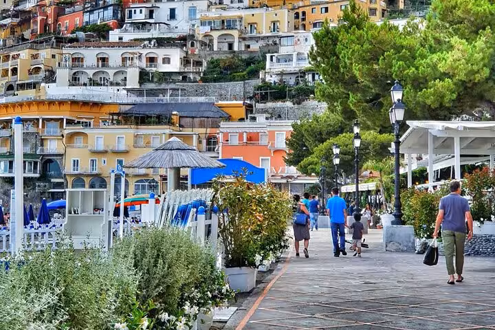 Scenic walkway in Positano with vibrant hillside buildings and lush greenery along the Amalfi Coast.