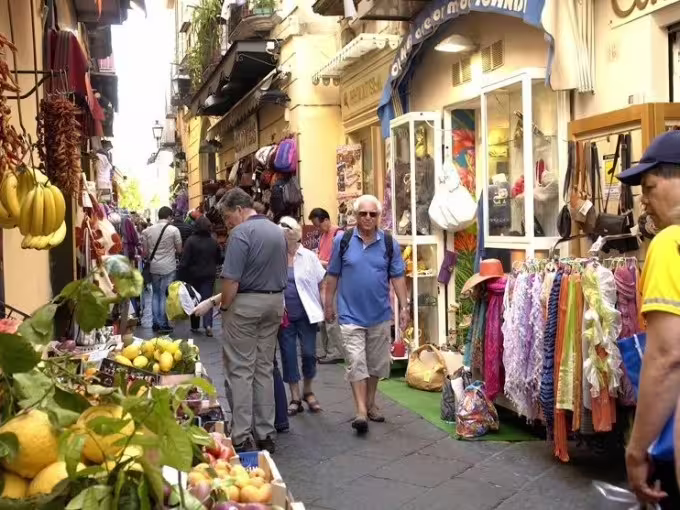 Crowded Positano shopping street with local stalls, included on Sorrento Positano Amalfi Coast group tour from Naples