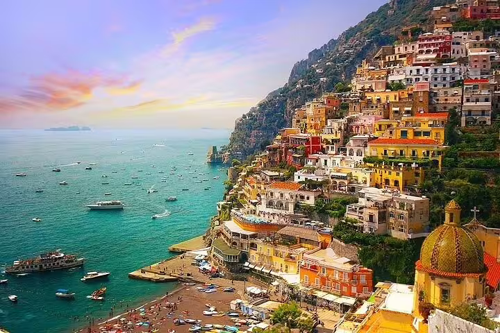 Sunset view of Positano’s pastel houses and lively marina on a luxury private Amalfi Coast and Pompeii ruins day trip
