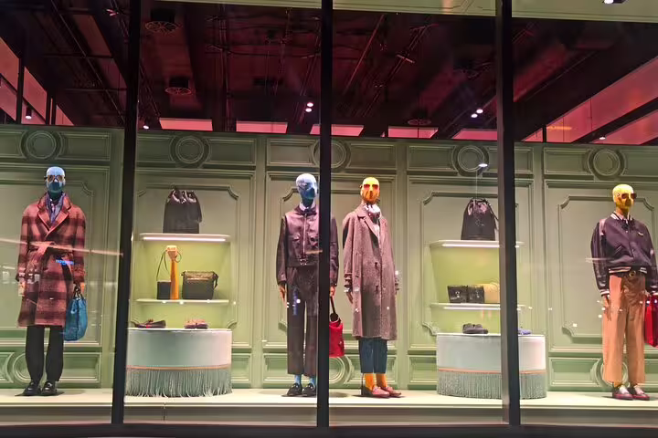 Elegant Prada store window at The Mall outlet with designer mannequins, luxury handbags and accessories on display