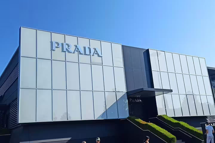 Modern glass-front Prada outlet at The Mall Firenze, ideal stop on a luxury shopping tour from Florence with designer deals