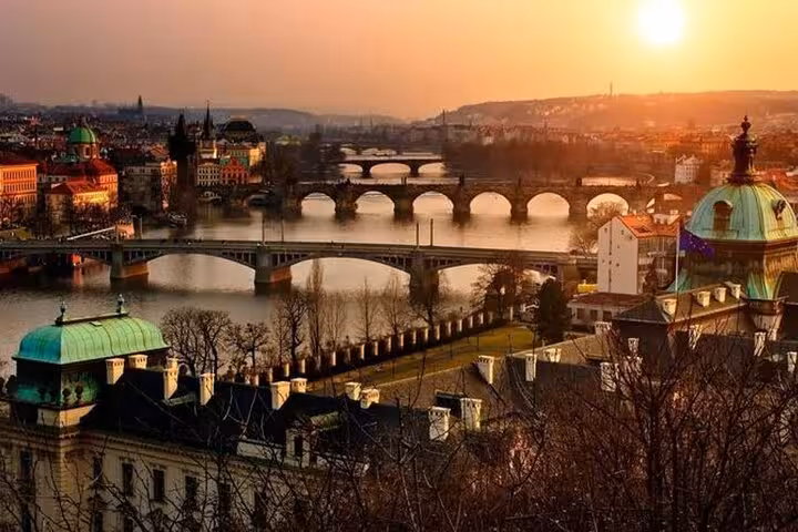 Panoramic Vltava River and Prague bridges at sunset, scenic highlight on Vienna to Prague small-group day tour