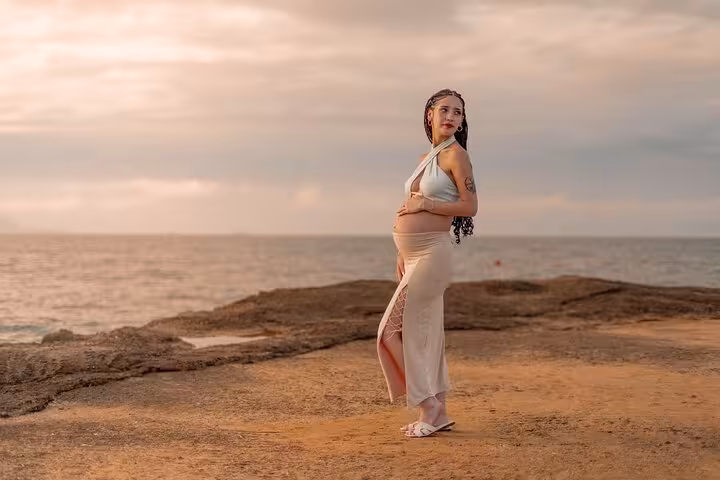 Pregnant woman posing gracefully by the sea in Analipsi, highlighting serene beauty and maternal elegance.