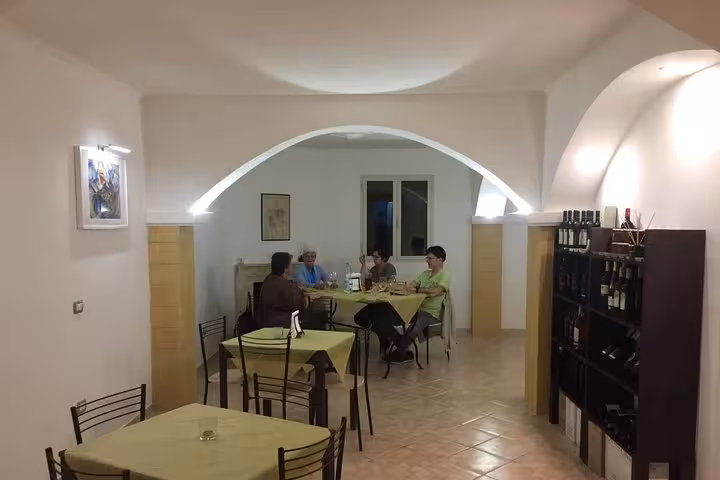 Guests enjoy a cozy dining experience in a rustic setting, sampling dishes featuring premium extra virgin olive oil.