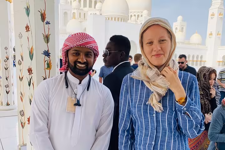 Private Abu Dhabi tour guide with visitor at Sheikh Zayed Grand Mosque, multilingual cultural experience