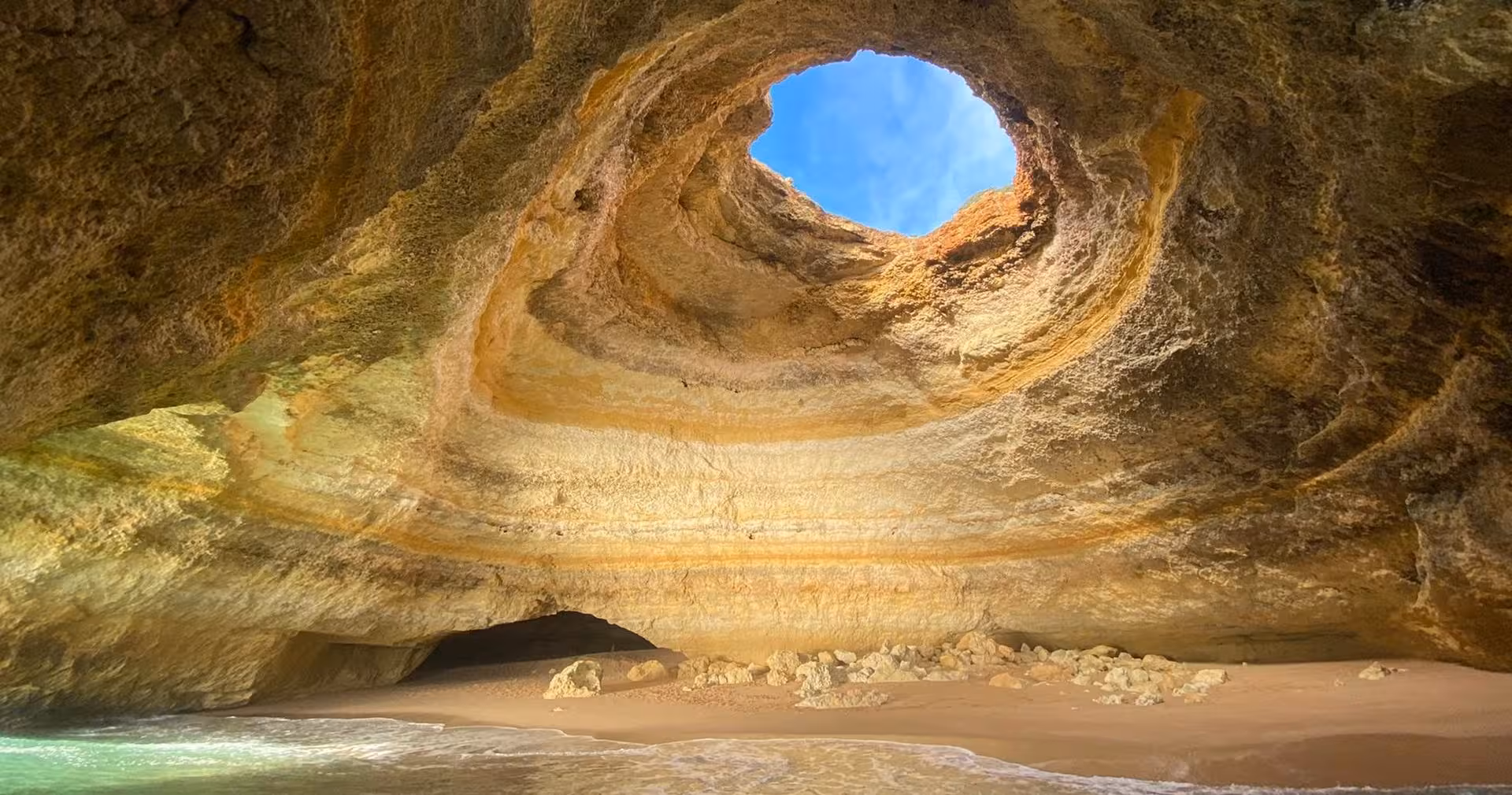 Private 2-hour Algarve boat tour to Benagil Cave, showcasing golden rock dome, hidden sandy beach and turquoise Atlantic water