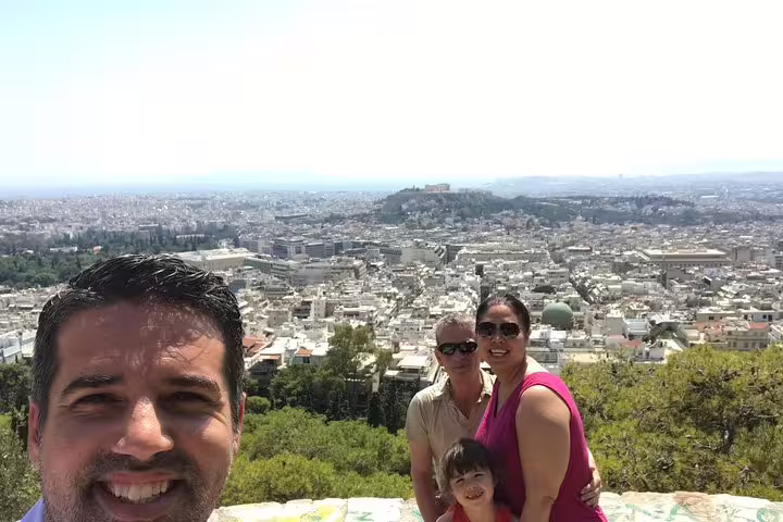 Family enjoying Athens viewpoint during a private 2-hour sightseeing experience, with sweeping city panorama behind