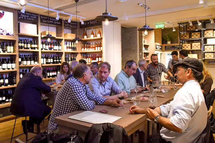 Travelers enjoying Greek wine tasting at an Athens deli stop during a private half-day city tour