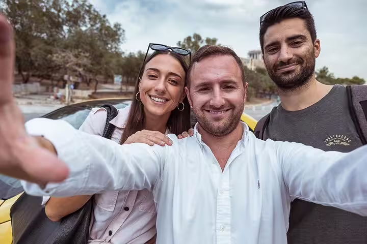 Happy travelers pose for a selfie on a private Athens layover city tour with pickup from airport or port