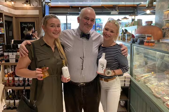 Guests posing with local Greek products in an Athens market on a private half-day sightseeing tour