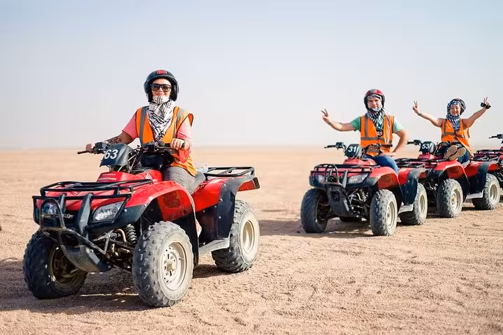 Group riding private ATV quad bikes in Sinai desert from Sharm El Sheikh, guided adventure with helmets