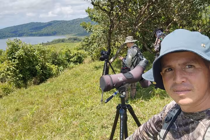 Bird watchers with scopes on a scenic hillside during a private half-day bird watching tour.