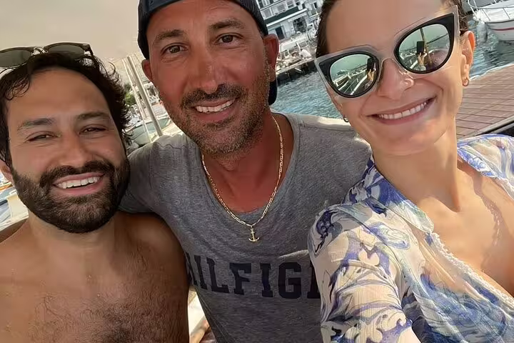 Happy guests selfie on private boat tour in Capri marina, 2-hour cruise along the island’s coast