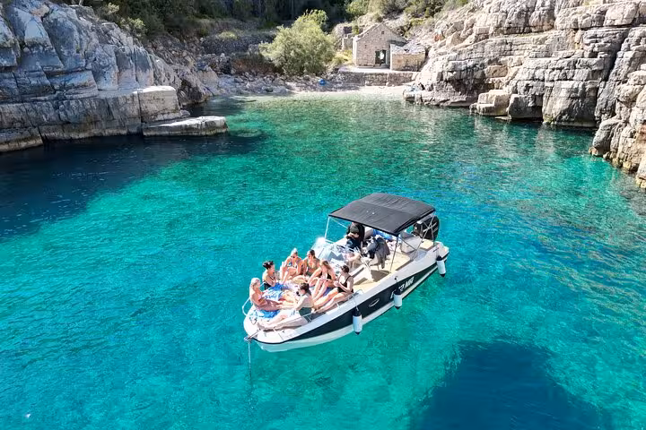 Private boat tour in Croatia with friends swimming in a crystal-clear Adriatic lagoon between rocky cliffs