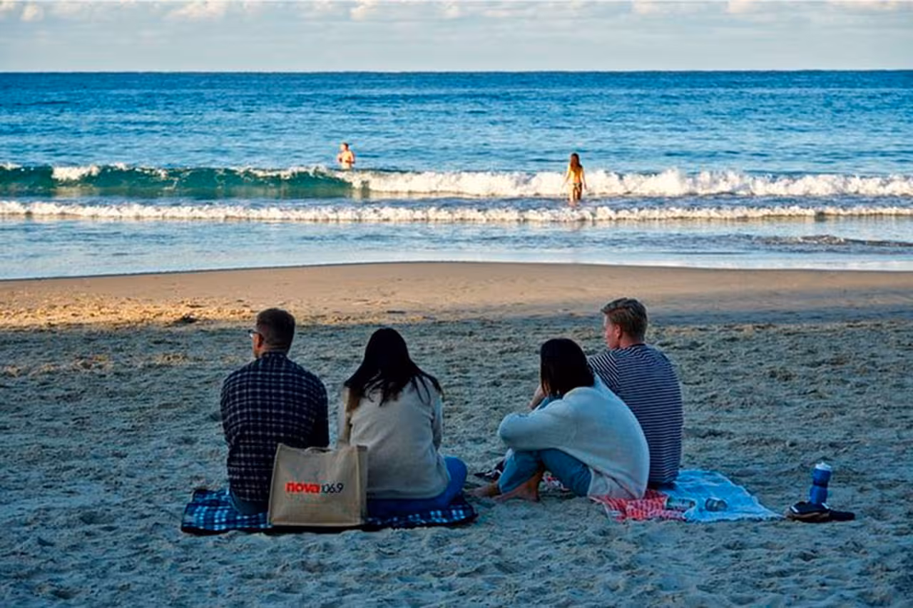 Group relaxing on sandy Algarve beach after a private boat tour from Faro, with Atlantic waves in view