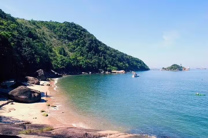 Scenic coastal view of a serene bay with a boat, ideal for a full-day private tour in Santos including barbecue.