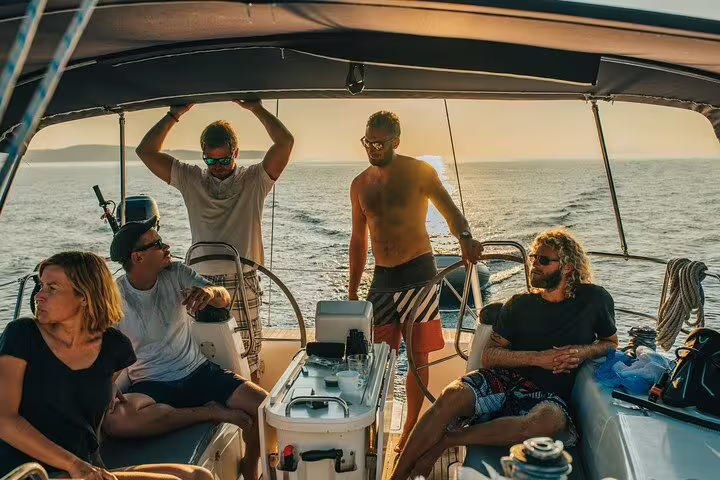 Group relaxing on a private boat tour in Santos, enjoying sunshine and ocean views with barbecue and drinks.