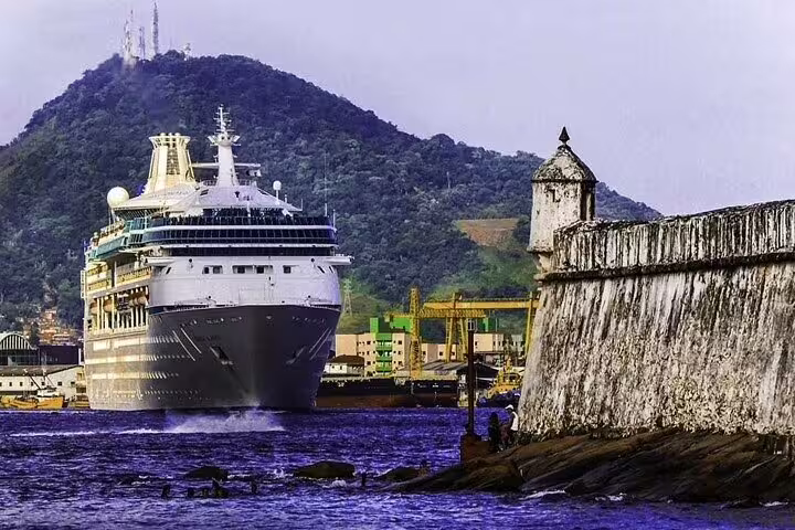 Cruise ship docking at Santos port with a scenic mountain backdrop, ideal for private boat tours in Brazil.