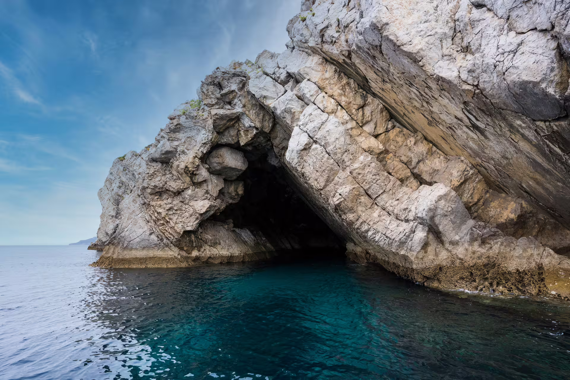 Explore the stunning rocky cave formations on a private boat tour in Sesimbra's Arrábida Park with crystal-clear waters.