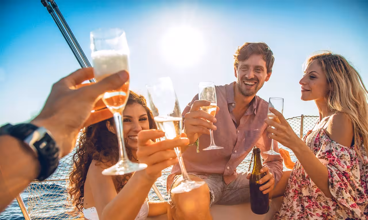 Friends toasting champagne on a private half-day boat tour in Vilamoura enjoying a relaxing Algarve sea experience