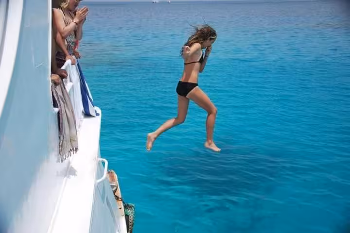 Guest jumping into crystal Red Sea from private boat trip in Hurghada to Sahl Hashesh and Makadi