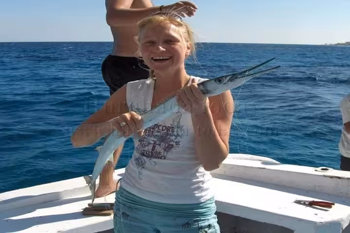 Guest holding a fresh catch on a private Red Sea boat trip from Hurghada, Sahl Hashesh and Makadi Bay