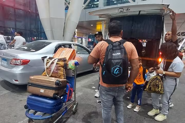 A family loads luggage into a van outside Cairo airport, beginning their Private 3 Days tour to the pyramids.