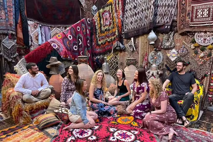 A group of tourists enjoys traditional Turkish decor in a vibrant carpet shop during a private Cappadocia tour.