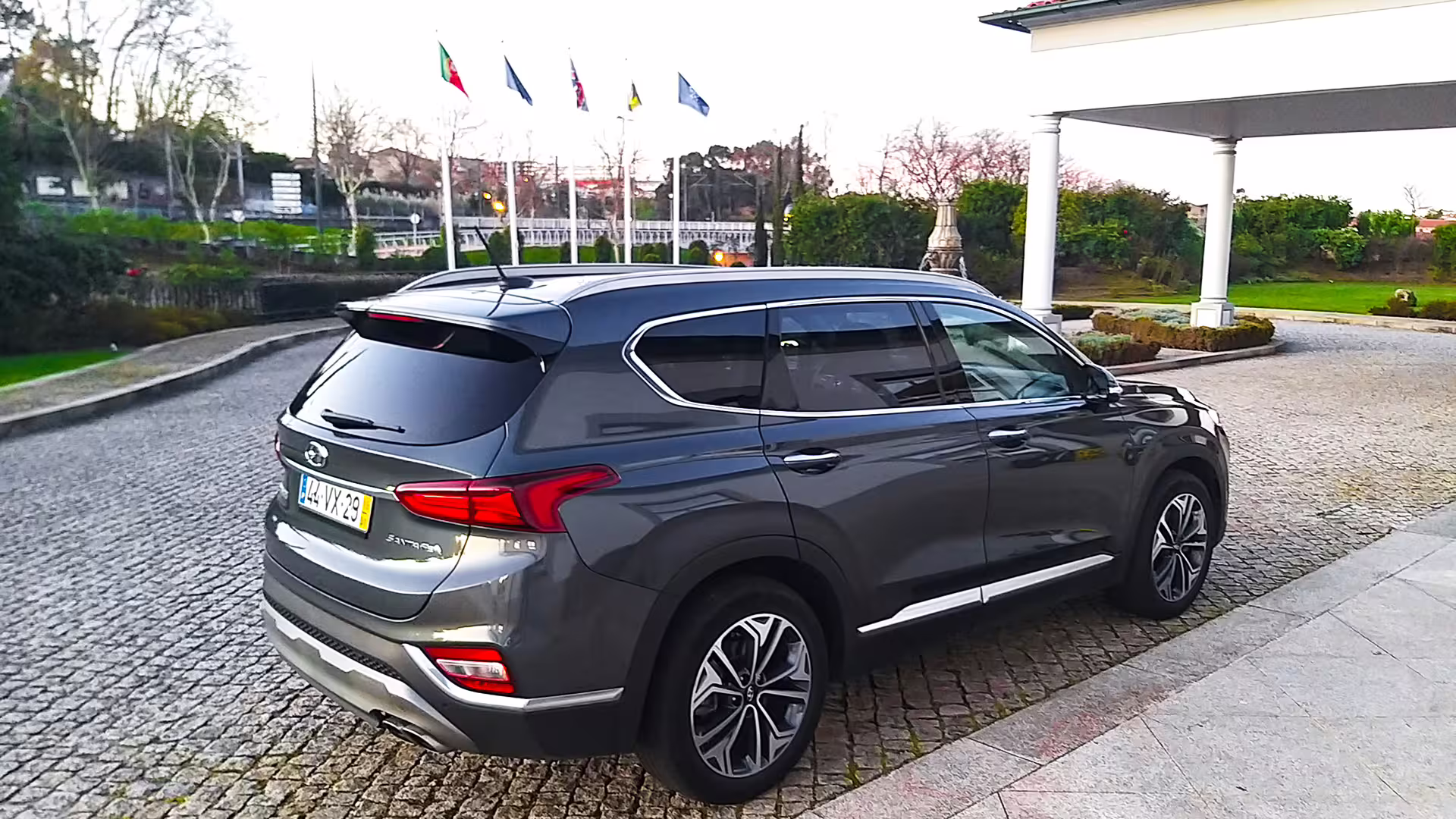 Private car parked on cobblestone driveway in Porto, ready for transfer to Pontevedra, showcasing a sleek modern SUV.
