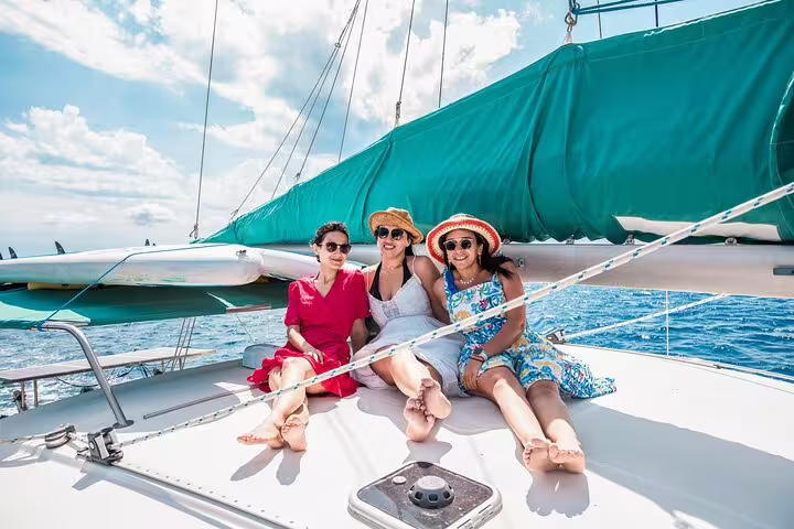 Group of friends enjoying a sunny day on a private catamaran trip in Ibiza and Formentera, surrounded by sparkling blue waters.
