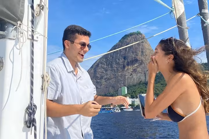 Happy couple celebrating on a private 3-hour catamaran sailboat with open bar in Rio, Sugarloaf backdrop