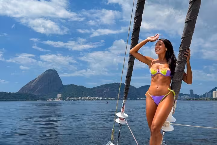 Woman relaxing on private catamaran in Rio with open bar, sailing past Sugarloaf Mountain