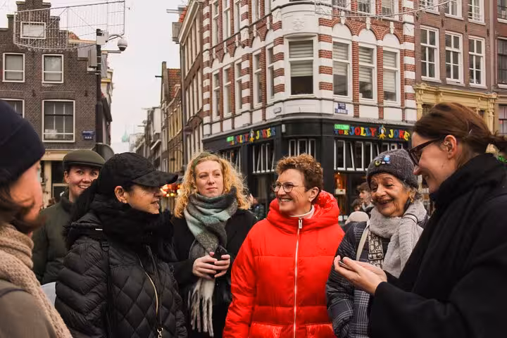 Small group meets a local guide on an Amsterdam street during a private city walking experience with a local