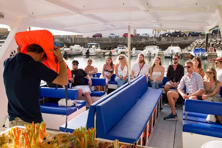 Tour guide demonstrating safety procedures to guests on a comfortable private cruise, highlighting an afternoon tea journey.