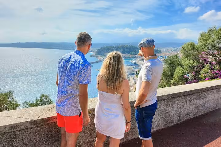 Three tourists admire panoramic views of the French Riviera coastline on a private excursion stopover.