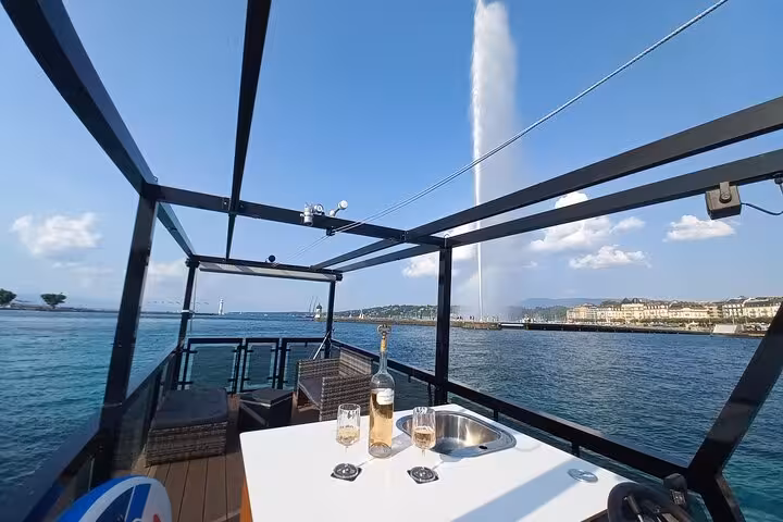 Luxurious private cruise on Lake Geneva with aperitif, showcasing the iconic Jet d'Eau under a clear blue sky.