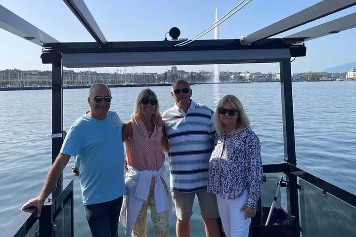 Group enjoying a private cruise on Lake Geneva with Jet d'Eau fountain in the background.
