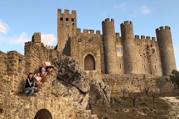 Visitors explore the historic medieval castle in Óbidos, Portugal, during a private day tour with guide to Fatima, Batalha, Nazaré, and Óbidos.